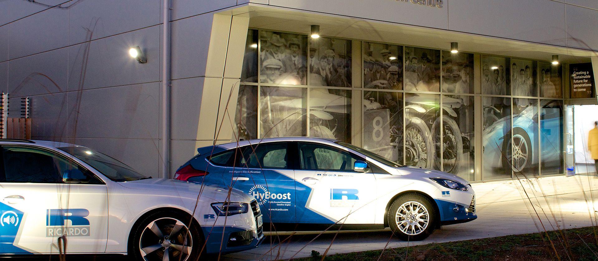 Two Ricardo branded cars infront of an innovation centre.