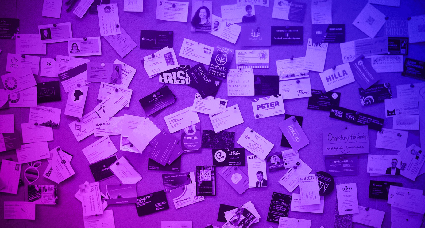 wall of business cards pinned to a cork board