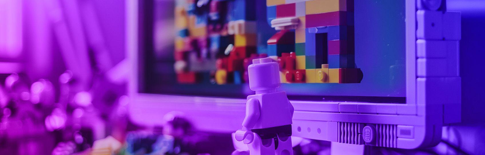A lego figure building a website using lego on a lego computer monitor