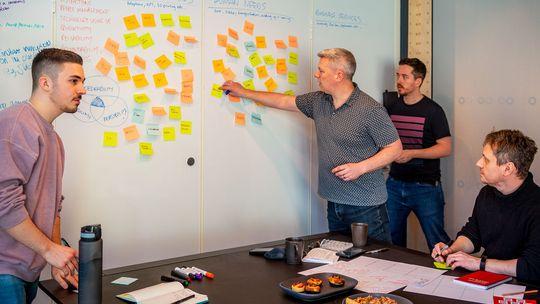 Research team pointing at made up post-it notes.