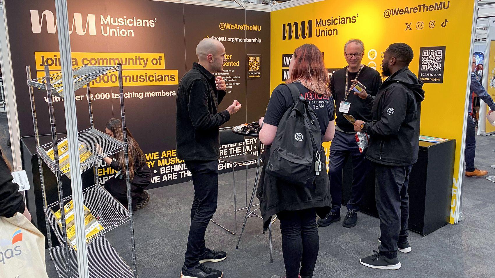 The MU at a exhibition with a stand.